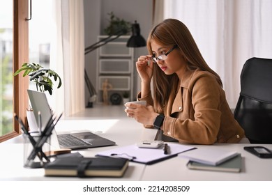 Focused Young Female Small Business Entrepreneur Wearing Glasses Reading Business Email On Laptop Computer