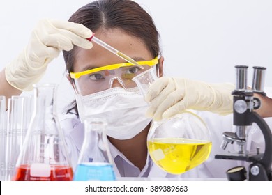 Focused young life science professional pipetting solution into the glass cuvette. Lens focus on the researcher's eye. - Powered by Shutterstock