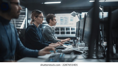 Focused Young Multiethnic Female Software Developer Working on Computer Together with Two Creative Male Colleagues. Data Protection Center with Servers, Storage Hardware and eBusiness Research - Powered by Shutterstock