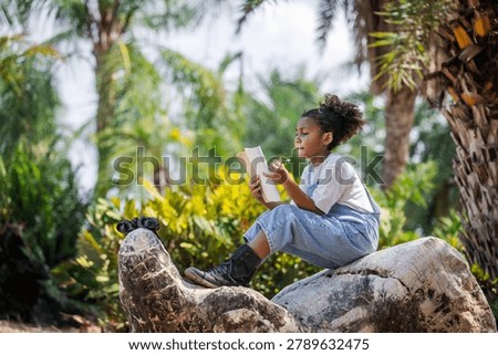 Focused young student taking notes during an outdoor STEM learning activity in a tropical botanical garden. The image highlights environmental education, scientific observation, critical thinking, sustainability awareness, and experiential learning in a natural setting.