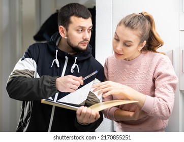 Focused Young Woman Discussing Apartment Lease Agreement With Landlord, Reading Papers At Home..