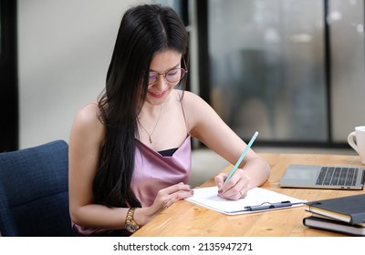 Focuses Young Female Financial Adviser Checking Financial Report At Office Desk.	