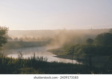 Fog above white river. Zhizdra river and riverbank covered with morning fog. White fog reflected in the river water. - Powered by Shutterstock