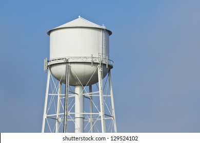 Fog clears revealing a white water tower.