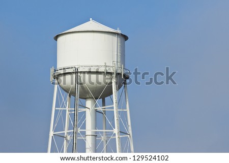 Fog clears revealing a white water tower.