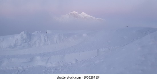 the fog and the clouds hide the tip of the mountain that tries to emerge timidly