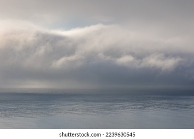 Fog clouds low above the calm water of the Irish Sea. 