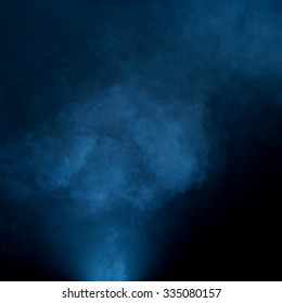 Fog floating and swirling on black background with blue tint. 