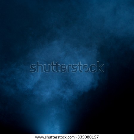 Fog floating and swirling on black background with blue tint. 