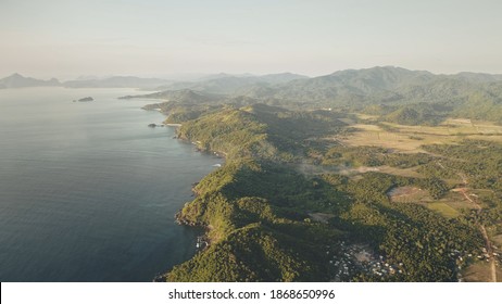 Fog haze over mountains tops at Philippines countryside aerial. Rural settlement with buildings at green forest hills in mist. Epic nobody tropic nature landscape. Cinematic soft light drone shot