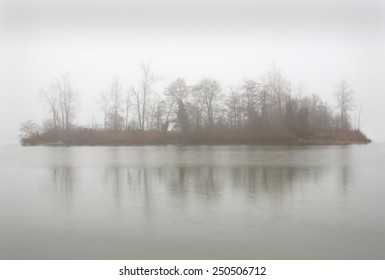 Fog Island. Calm Water Surrounds An Island During A Foggy Day In The Pacific Northwest.
