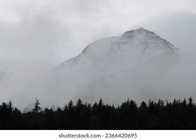 Fog lifting off the snowy peaks. - Powered by Shutterstock
