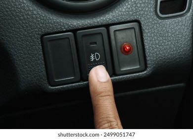 The fog light button is turned on when it is raining and foggy while driving