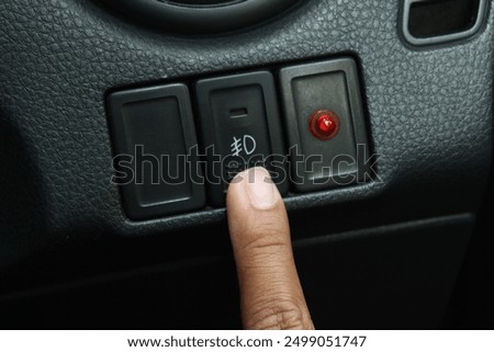 The fog light button is turned on when it is raining and foggy while driving