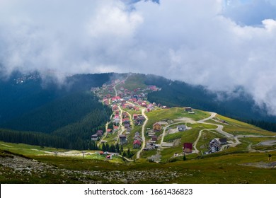 Fog and low clouds over village near Transalpina road DN67C. This is one of the most beautiful alpine routes in Romania and the highest mountain asphalt road in Romania and  Carpathians mountains.