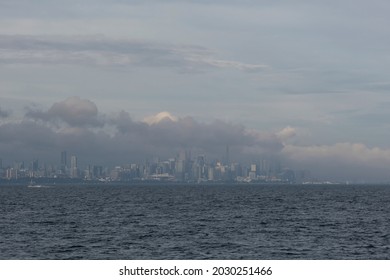 Fog and mist over lake Ontario water surface covers Toronto city skyline, heavy clouds on the sky. Weather conditions, advisory, alert concept. Space for copy. - Powered by Shutterstock