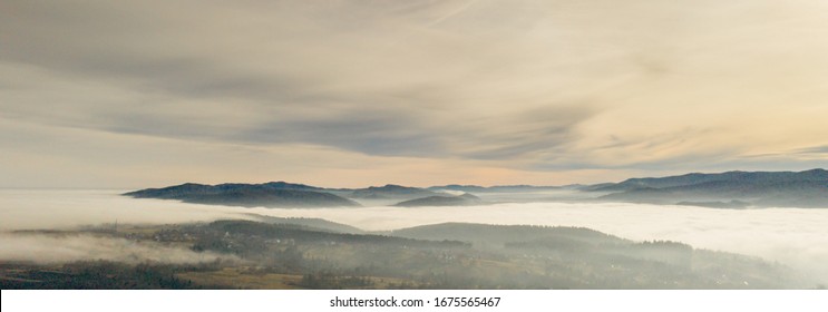 Fog in mountains before sunrise, mountain valley with clouds. View to mountains of the Carpathians.