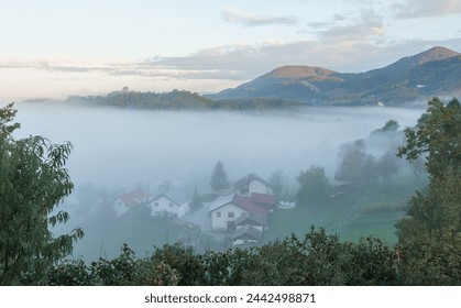Fog in the mountains early in the morning. Mountain village in Slovenia, Europe. - Powered by Shutterstock