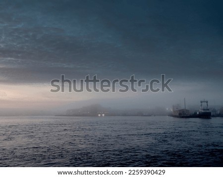Fog over Claddagh and Galway port. Blue sky and ocean. Nature scene with calm muted colors.