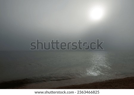 Fog over the sea and the morning sunrise, gloomy morning. Exfoliation, advection fog - cooling of warm moist air when it moves over a colder surface of water,
marine landscape