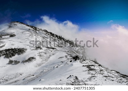 Fog rising from the valley and engulfing a mountain ridge; Mount San Antonio (Mt Baldy),south California