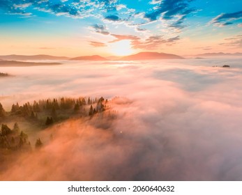 Fog spreads over the mountains at dawn. The sun rises on the horizon. Ukrainian Carpathians in the morning. Aerial drone view. - Shutterstock ID 2060640632