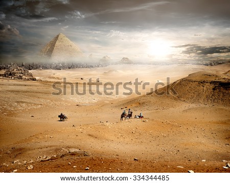 Fog and storm clouds over pyramid in desert