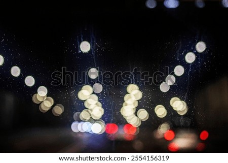 fogged windshield with streaks while driving on a lighted highway at night