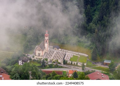 Foggy aerial view over a small cemetery and church from Tyrol , Alps Mountains landscape,Austria