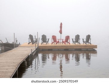 Foggy August morning on Spring Lake. Cottage country, Ontario, Canada. Fog mist misty. Low visibility. Chair chairs Muskoka Adirondack. Floating wood wooden dock. Motor boat. Calm still water. Reflect - Powered by Shutterstock