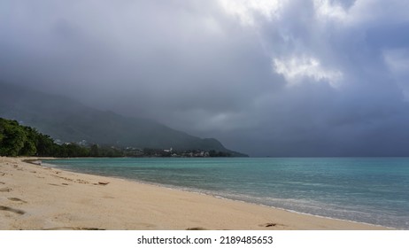 A foggy day on a tropical island. The turquoise ocean is calm. Footprints on a sandy beach. The mountain is hidden in low clouds. Seychelles. Mahe. Beau Vallon - Shutterstock ID 2189485653