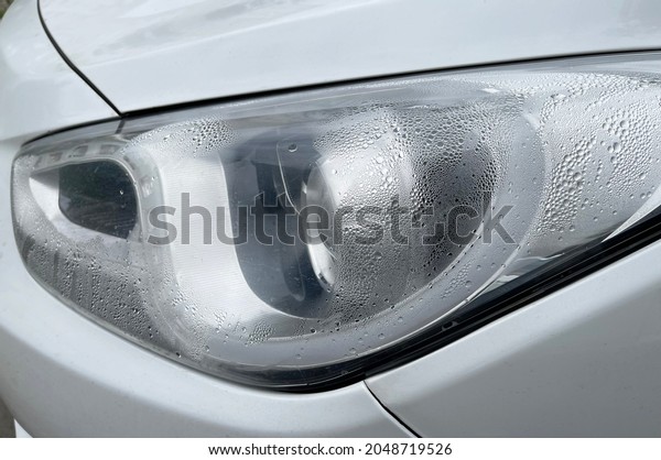 Foggy\
headlight with condensation in a modern\
car