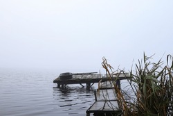 Foggy Morning On The Lake. Old Fishing Boats And A Wooden Pier For Fishing And Recreation On The Water. Fishermen On A Boat. Autumn Foggy Morning, Countryside.