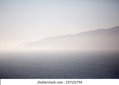 Foggy  mountains next to an ocean