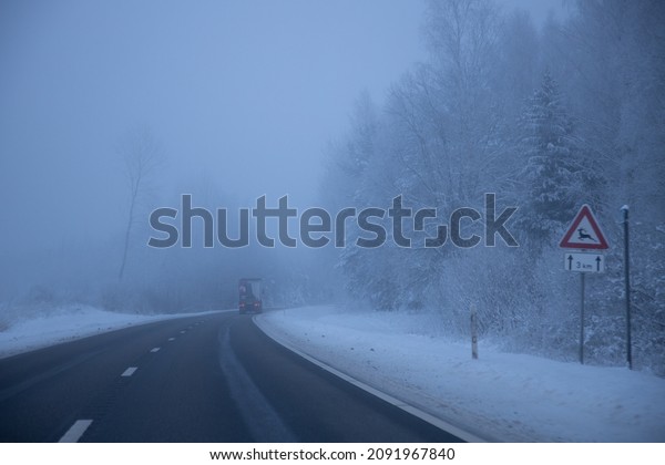 Foggy road in the evening. Winter asphalt road\
blurred. Blurred photo