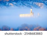 Foggy valley in city residential with granary building grainary in golden morning sunlight