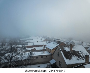 Foggy winter morning over snow-covered rooftops of residential neighborhood - Powered by Shutterstock