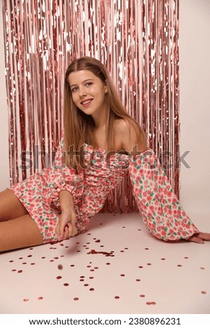 foil pink rain curtain for the photo zone. birthday barbie photo. beautiful stylish girl in a short pink dress in the studio. 16th birthday. romantic date wear pink cute dress 