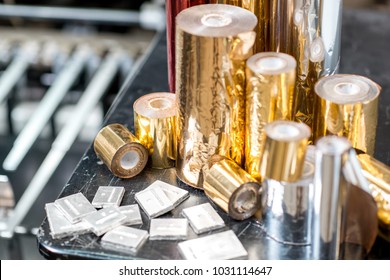 Foil rolls and cliche for stamping on the press machine at the printing manufacturing - Shutterstock ID 1031114647