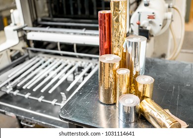 Foil rolls for stamping on the press machine at the printing manufacturing - Shutterstock ID 1031114641