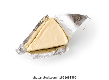 Foil wrapped processed creame cheese slice isolated on a white background. Small triangular piece of portioned soft cheese in a silver aluminium foil. Tasty sandwich ingredient. Macro. Top view.