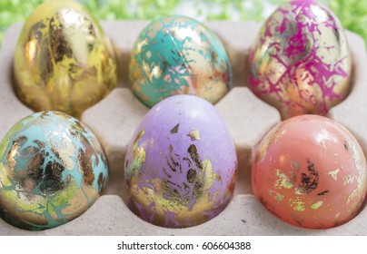 Foiled and Colorful Easter Eggs in Pink, Aqua, Yellow, Orange and Gold, in an egg container - Powered by Shutterstock