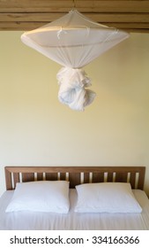 Fold Mosquito Net Over A Bed In Bedroom.