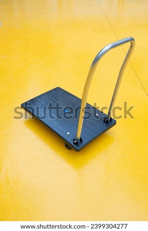 foldable handcart on a yellow background at vertical composition