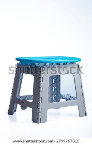 Foldable polypropylene step stool with blue seat and gray frame isolated on white background
