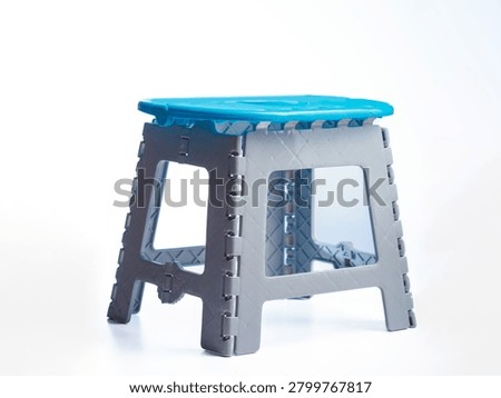 Foldable polypropylene step stool with blue seat and gray frame isolated on white background