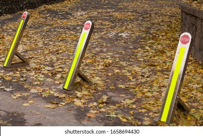 Foldable street bollards. No parking and no entrance posts. Delineators. Stop sign. Asphalt covered with fallen autumn leaves. - Shutterstock ID 1658694430