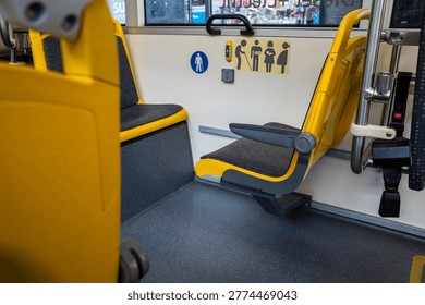 Foldable yellow priority seating area inside a modern empty public city bus, perfect for illustrating accessible public mass transit.