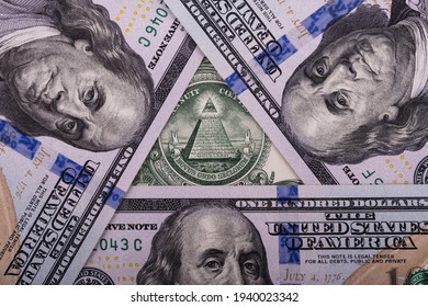 Folded 100 American Dollar Bills In A Triangle, In The Center Of Which Is A Fragment Of A 1 USD Bill With A Pyramid And An All-seeing Eye