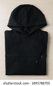 Folded Blank Black Hoodie Sweatshirt Long Sleeve Mockup Plank On The Floor. Template For Place Your Design.